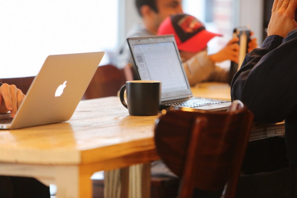 カフェでノートパソコンを開く男性